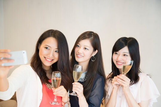 シャンパンを持って自撮りをしている女性たち