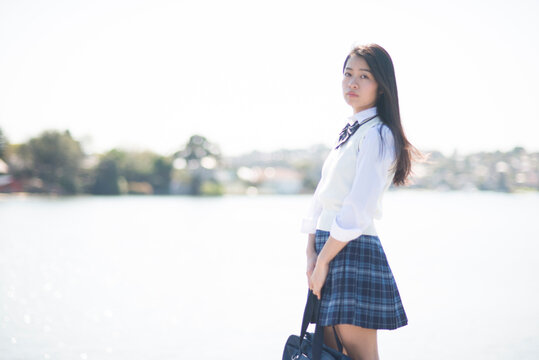 水辺に立っている制服姿の女子高生