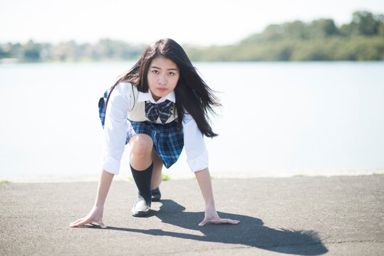 位置についてのポーズをしている制服姿の女子高生