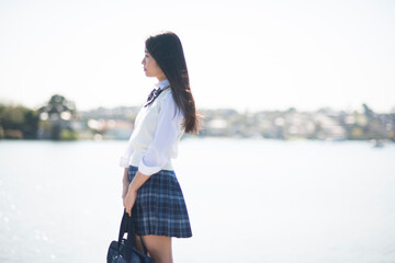 水辺に立っている制服姿の女子高生
