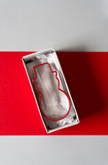 snowman christmas cookie cutter inside a grungy old box on red paper