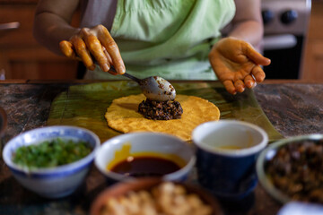Close up of hands preparing hallaca or tamale. Traditional food concept