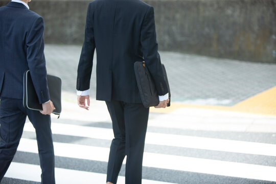 外回りをするスーツ姿の20代男性2人