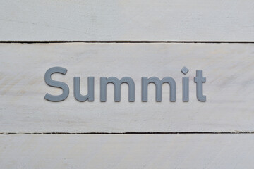 Grey Summit letters printed in 3D. Target to reach message. Letters presented on rough whitish wood board background