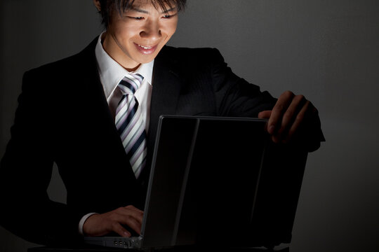 ノートパソコンを開くビジネスマン