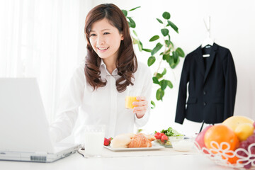 ノートパソコンを見ている出勤前の女性