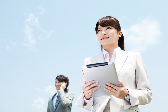 タブレットPCを持つビジネスウーマンとビジネスマン