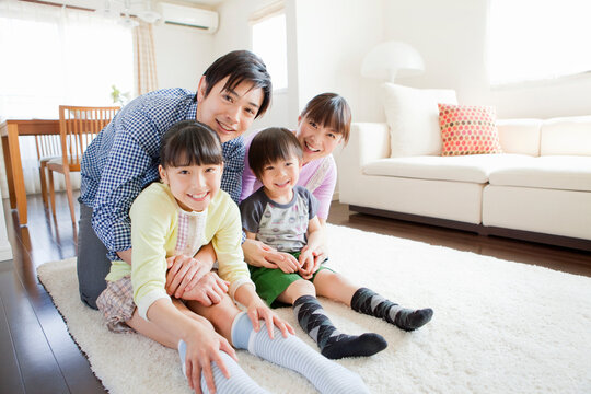 笑顔で寄り添う家族4人