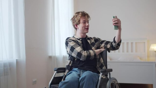 A beautiful disabled man is talking with his friend on the Internet 