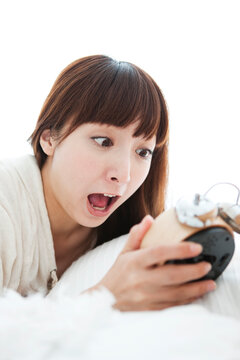 目覚まし時計を持つ女性