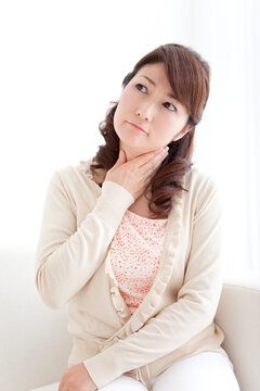 喉に手をあてる女性