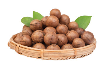 Macadamia nuts with leaves in a straw basket isolated