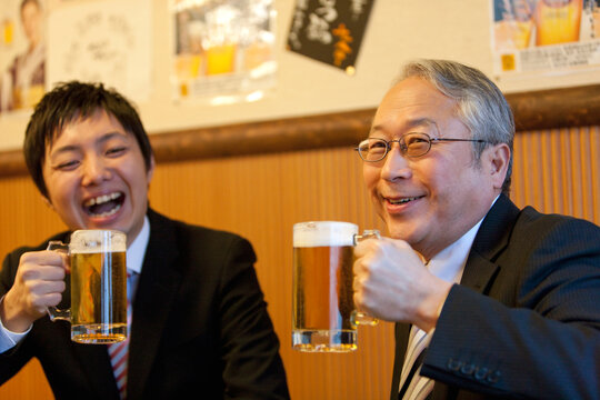 ビールを持つ笑顔のビジネスマン2人