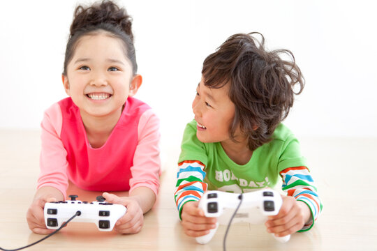 テレビゲームをしている子供2人