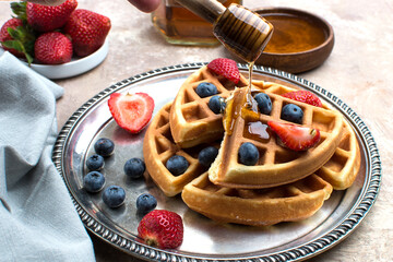 Waffles with blueberries, strawberries and honey