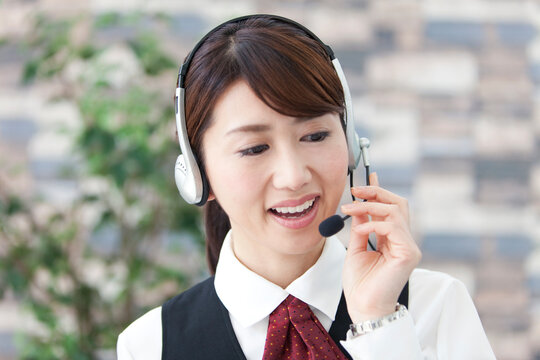 インカムで話す制服姿の女性