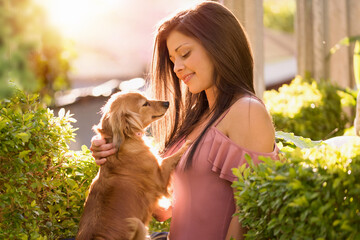 Mujer con su mascota al atardecer, compartiendo con mucho amor.  (Mujer con su perro)