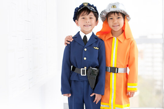 警察官と消防士の格好をしている子供2人