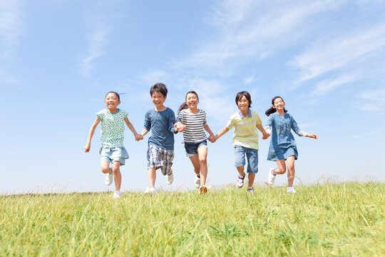 手をつないで走っている子供5人