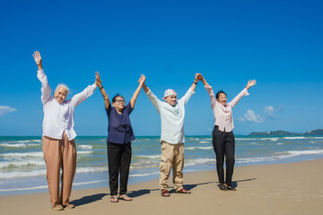 Obraz premium Happy Asian family holding hands and having fun together on tropical beach. Happy family standing on the beach. family travel and vacations concept