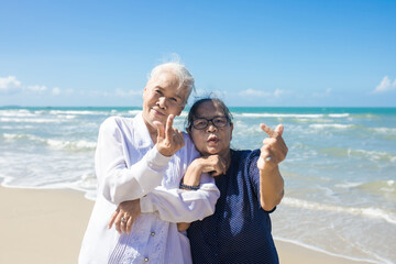 Portrait of happy senior asian female friends at beach. Senior woman friends relax at the beach. family travel and vacations concept