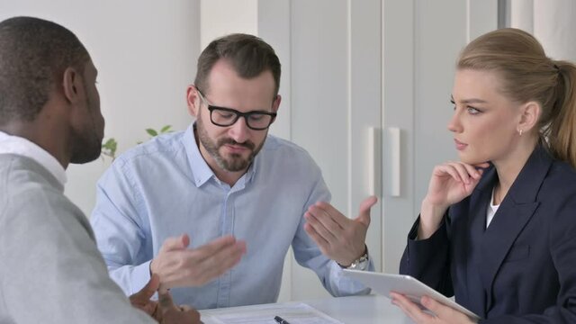 Angry Businessman Scolding Male and Female Colleagues during Meeting