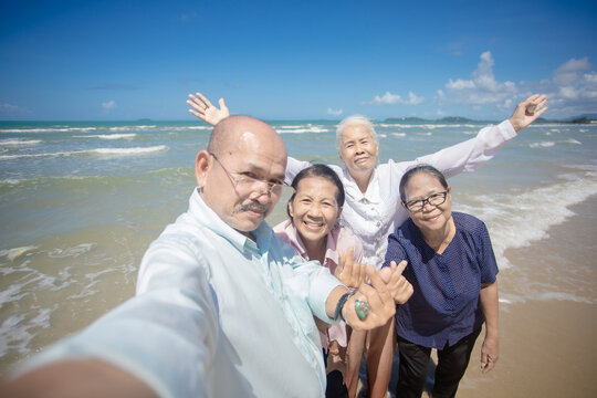 Senior friends taking selfie on the beach. Group of senior people making selfy picture