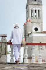 man dressed in white in cuetzalan standing on the balustrade