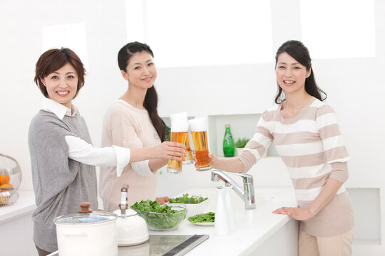 ビールで乾杯する中高年女性3人