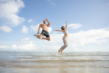 young couple walking at each other at beach. Romantic couple walking on sea, enjoying life and each other at honeymoon vacation.