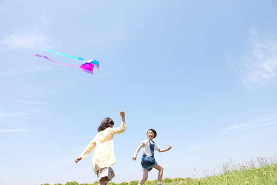 凧揚げをして遊ぶ女の子2人