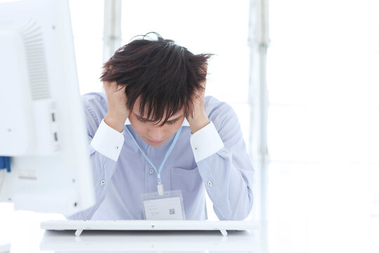 パソコンの前で頭を抱えるビジネスマン