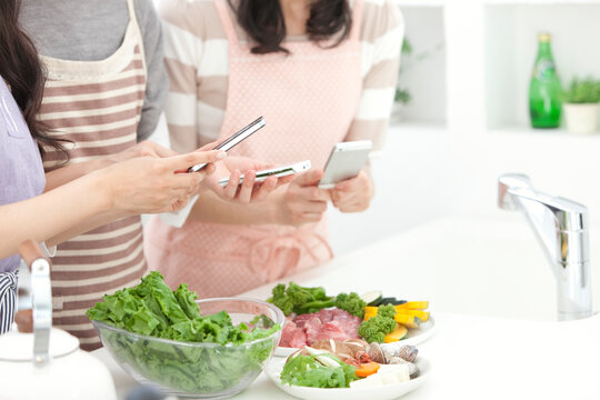 食材の写真を撮る中高年女性3人