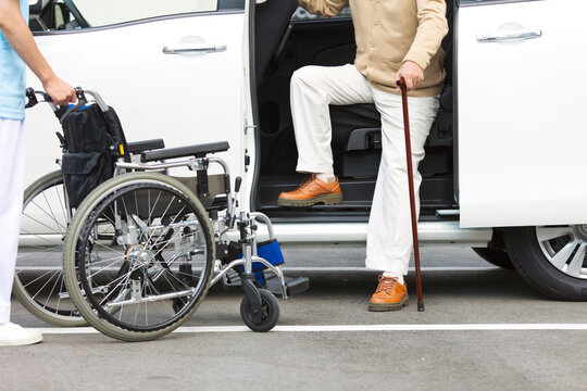 車から降りる杖をつく中高年男性