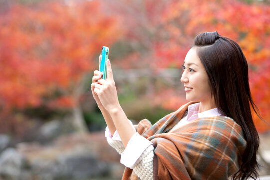 スマートフォンで写真を撮る女性
