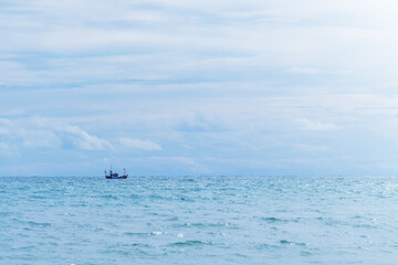 A small fishing boat sailing in the sea.In calm water in the  afternoon