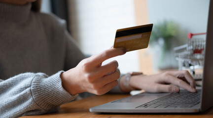 Online payment,Young woman's hands using computer and hand holding credit card for online shopping