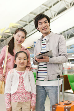 空港でタブレットPCを持つ3人家族