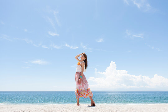 海岸でポーズをとっている笑顔の女性