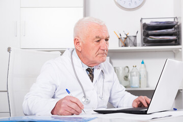 Male doctor having a productive day helping in his office