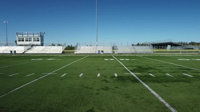Dolly shot of Football field and bleachers 