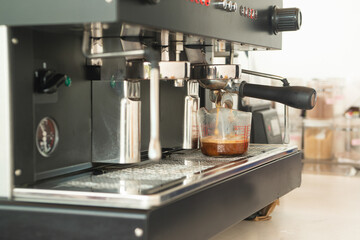 Large coffee machine and black mug while making coffee. Small business concept..