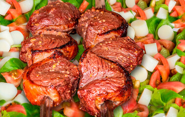 Brazilian barbecue with steak on a salad. Selective focus.
