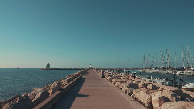 Go towards the lighthouse between the yachts and the sea, Grande Mottes, France