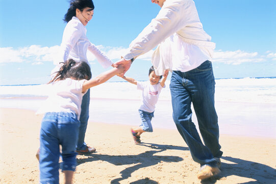 波打ち際で遊ぶ家族