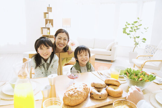 朝食の置かれたテーブルと笑顔の家族