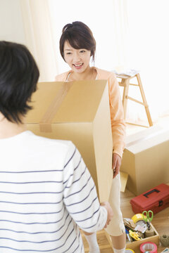 ダンボール箱を運ぶ若夫婦