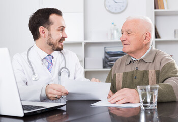 Aged man visiting consultation with man doctor in hospital