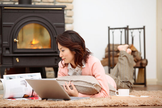 うつ伏せでパソコンを見る女性