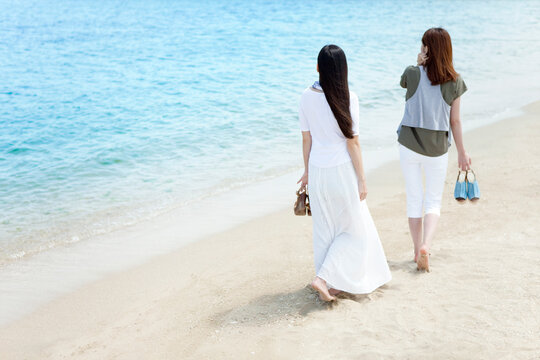 海辺を歩く女性2人